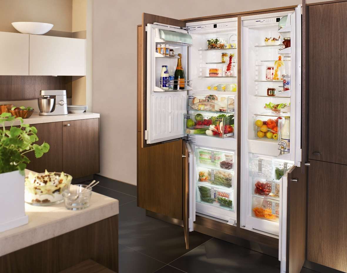 a small refrigerator in the facade of the kitchen in gray