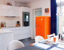 a small refrigerator in the facade of the kitchen in gray photo