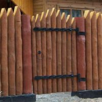 A fence of wooden stakes around a garden plot