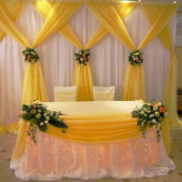 Yellow and beige fabrics in the design of the wedding table