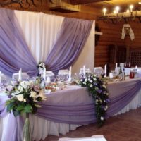 Bouquets of white roses at the corners of the wedding table