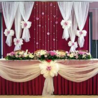 A burgundy tulle skirt around the edges of the bridal table