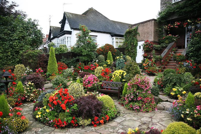 Blooming garden in front of the porch of an apartment building