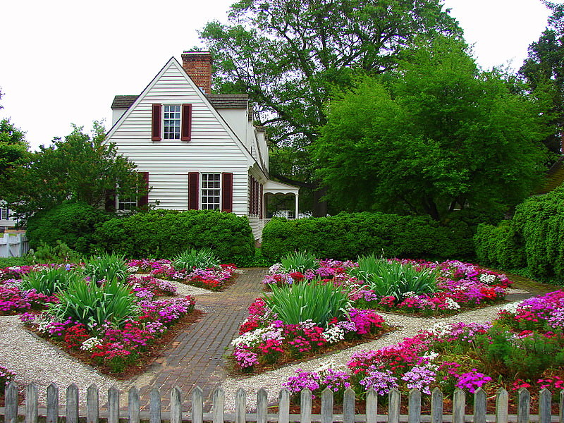 Flowerbeds of geometric shape in front of a country house