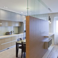 Zoning of the kitchen-living room with a decorative partition with wood trim