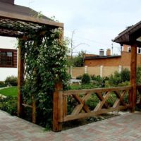 Pergola terbuat dari kayu di hadapan pintu masuk ke taman