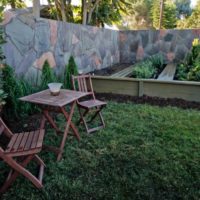 Folding wooden chairs and a table on a green lawn