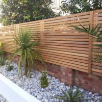 Wooden fence made of horizontal slats on a brick base