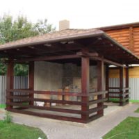 Garden gazebo with a brick stove in the corner of the cottage