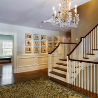 Wooden staircase with white railing in the lobby of a country house