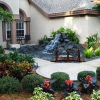 Waterfall on stones in front of the entrance to a residential building