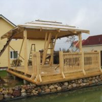 Wooden arbor on the shore of the pond