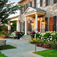 Registration of the main entrance to the private house with flowers and shrubs