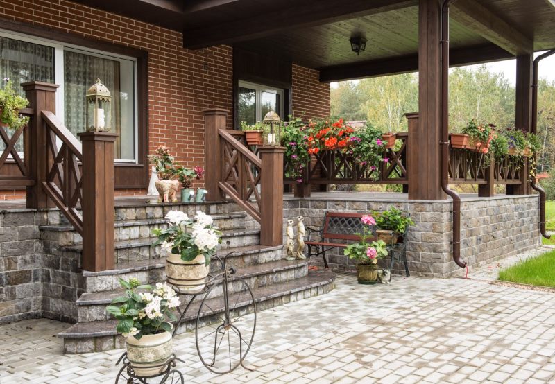 Decorating the porch of a country house with stone and wood