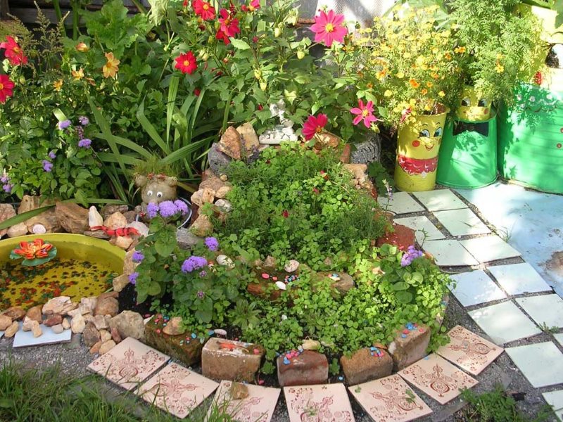 Flowerbed مع الزهور من الطوب القديم ونفايات البناء الأخرى.