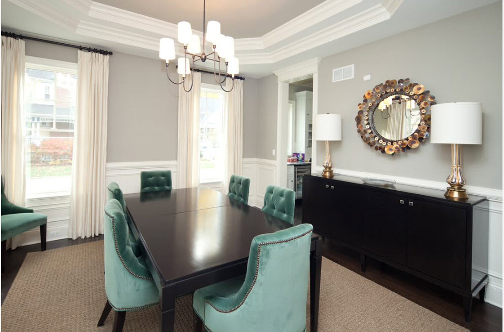 Mint-colored upholstered chairs at a black table in a bone