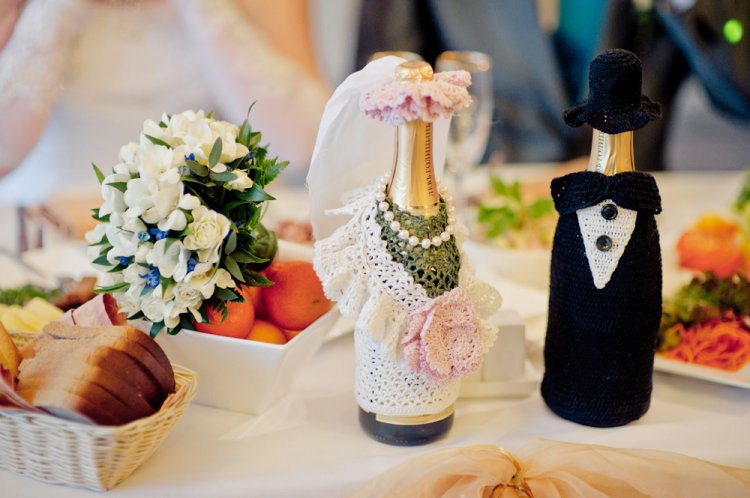 Making champagne with your own hands in dresses of the bride and groom