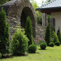 Stone fence with an arch at the entrance of the cottage