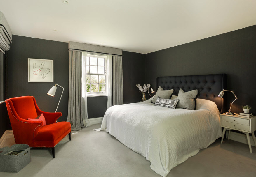 White hoodie on a black bed in a bedroom with gray walls