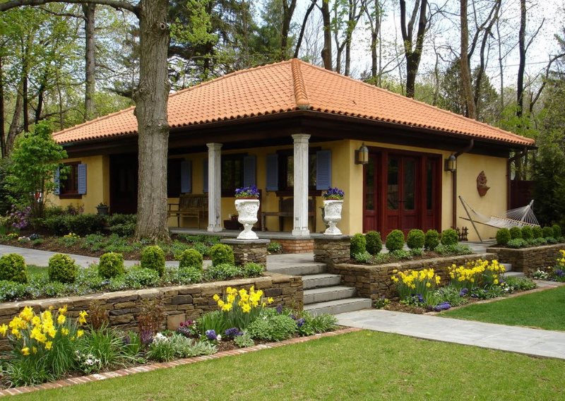 Retaining wall made of natural stone in front of the porch of a country house