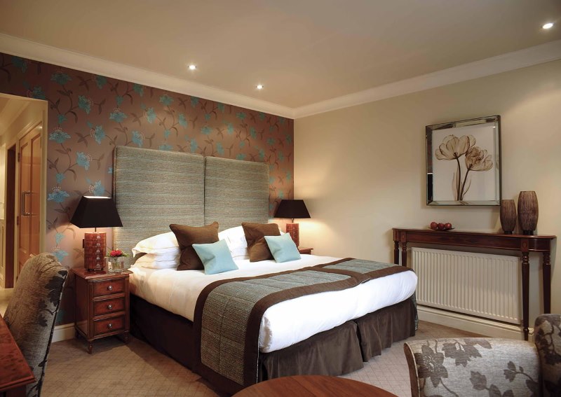 White bedspread on a brown bed in a bedroom of a private house