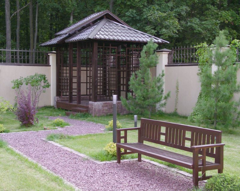 Arbor and shop in the same style, connected by a gravel path