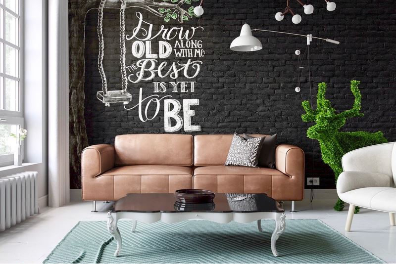 Sofa coklat terhadap dinding hitam dengan kertas dinding brickwork