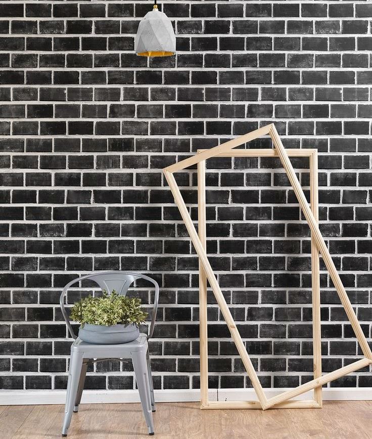 Wooden frames near the wall with black brick wallpaper