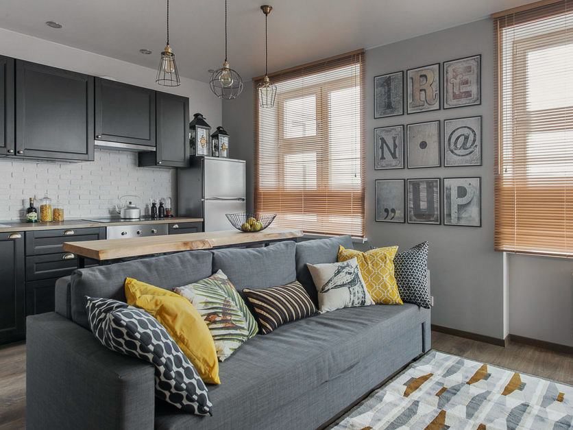 Gray sofa in the kitchen-living room in pastel colors