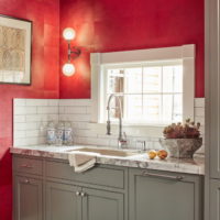 A sink in front of a window in the kitchen of a country house