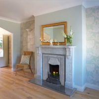 Large flowers on the wallpaper in the living room with fireplace