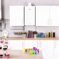 The combination of a white gas boiler with a kitchen set of the same color