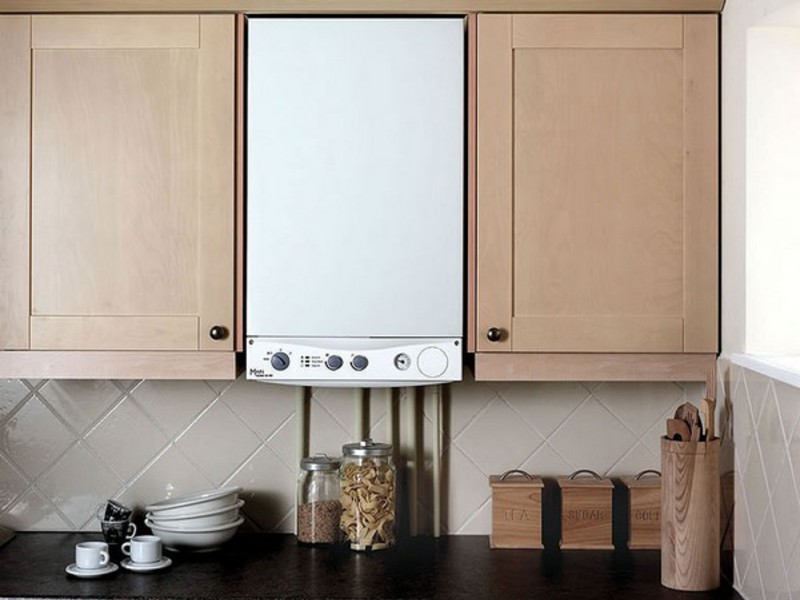 The combination of a white gas boiler with cream-colored facades of the kitchen