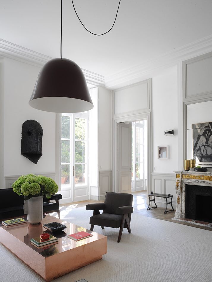 Chandelier with a black ceiling in the interior of the living room with a bleached ceiling