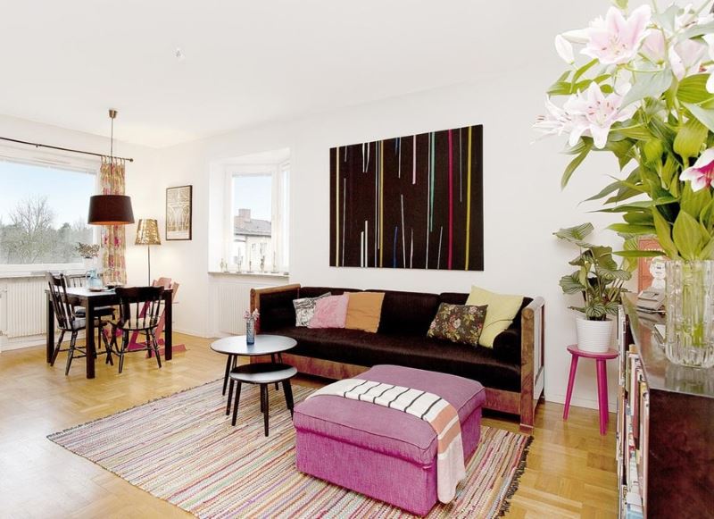 Living room interior in white with raspberry pouf