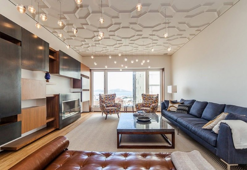 Design of a spacious hall with moldings on a white ceiling