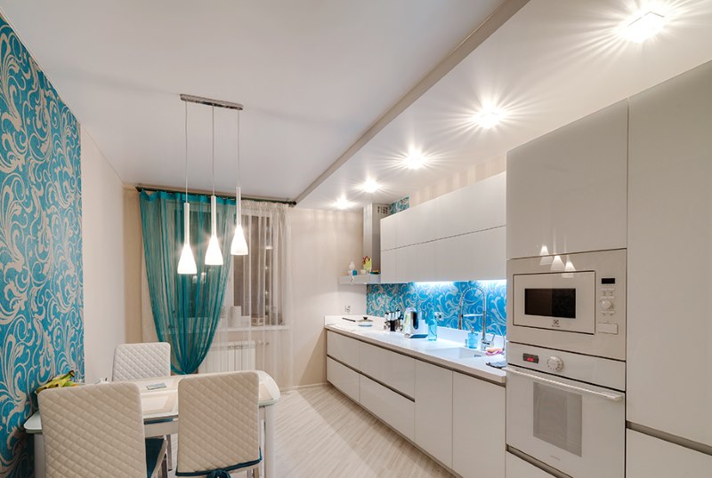 Illuminated two-level ceiling above the dining area in the kitchen of a city apartment