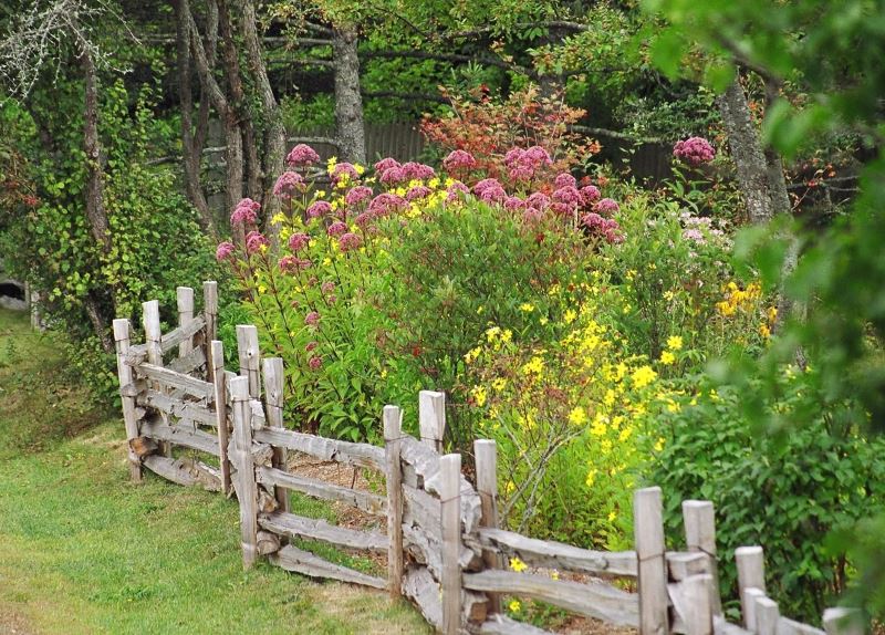 Old wooden fence in the design of the cottage