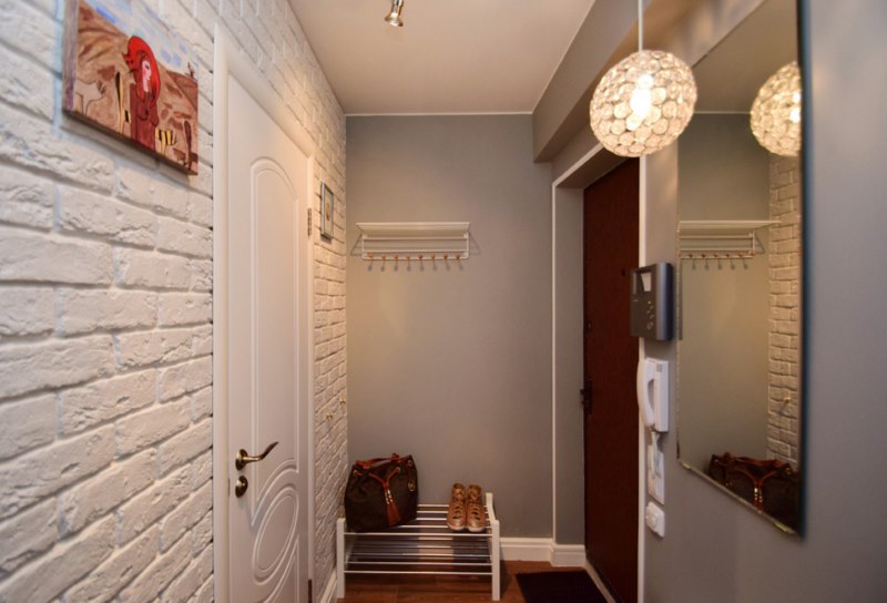 White brick wall opposite the mirror in the hallway