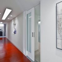 The combination of the red floor and the white door in the interior of the narrow corridor