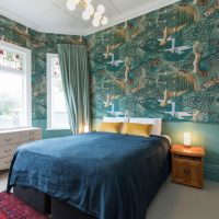 Turquoise wallpaper in the bedroom of a city apartment