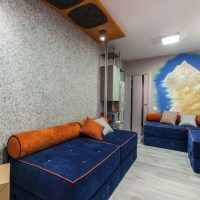 Sofa dengan pelapis biru di ruang tamu sebuah apartmen bandar