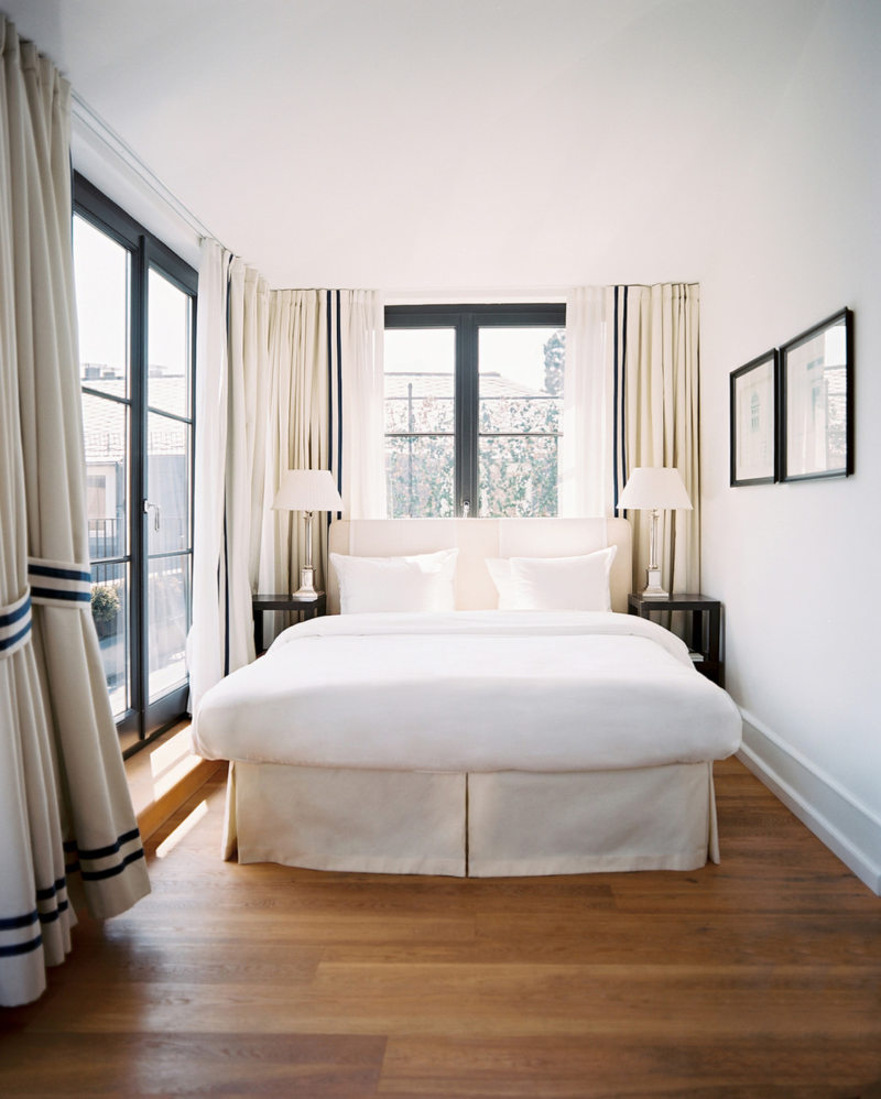 White bed on brown laminate floor