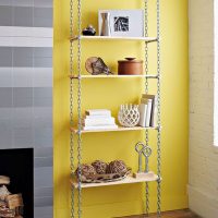 Shelves on chains against a yellow wall