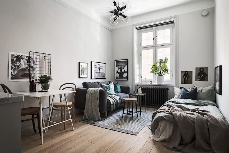 The interior of a rectangular studio apartment with one window