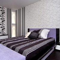 Striped bedspread in the bedroom with two types of wallpaper