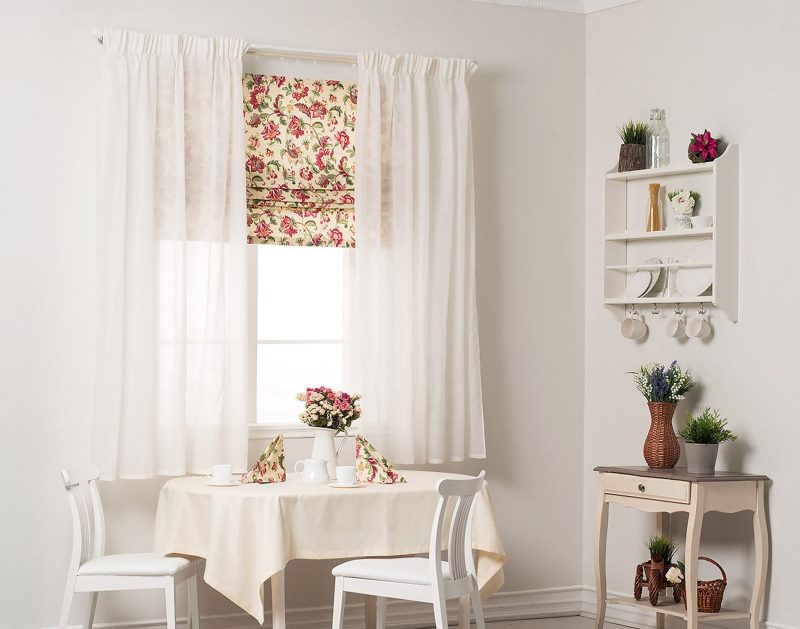 Interior of a bright kitchen with a Roman curtain on the window