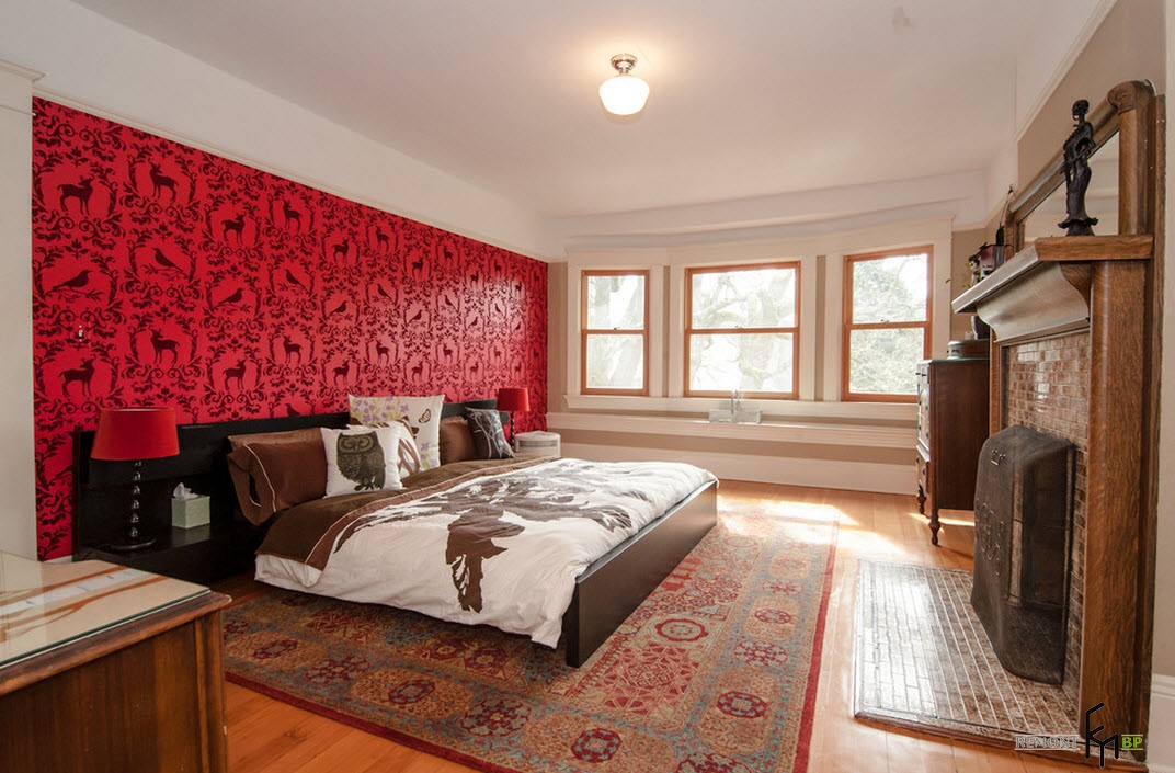 Wall with red wallpaper in a spacious bedroom