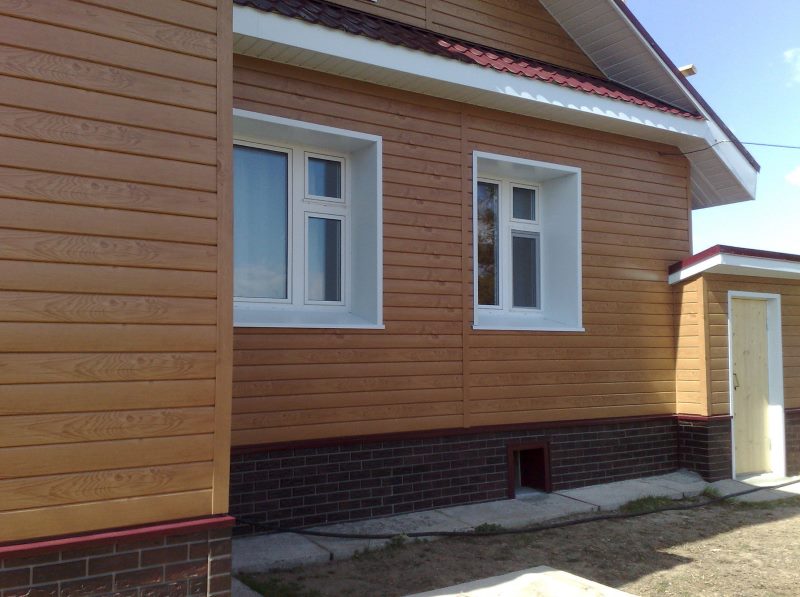 Galvanized steel siding with wood trim on the wall of a country house