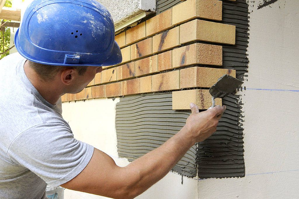 Installation of clinker tiles on the facade of the house